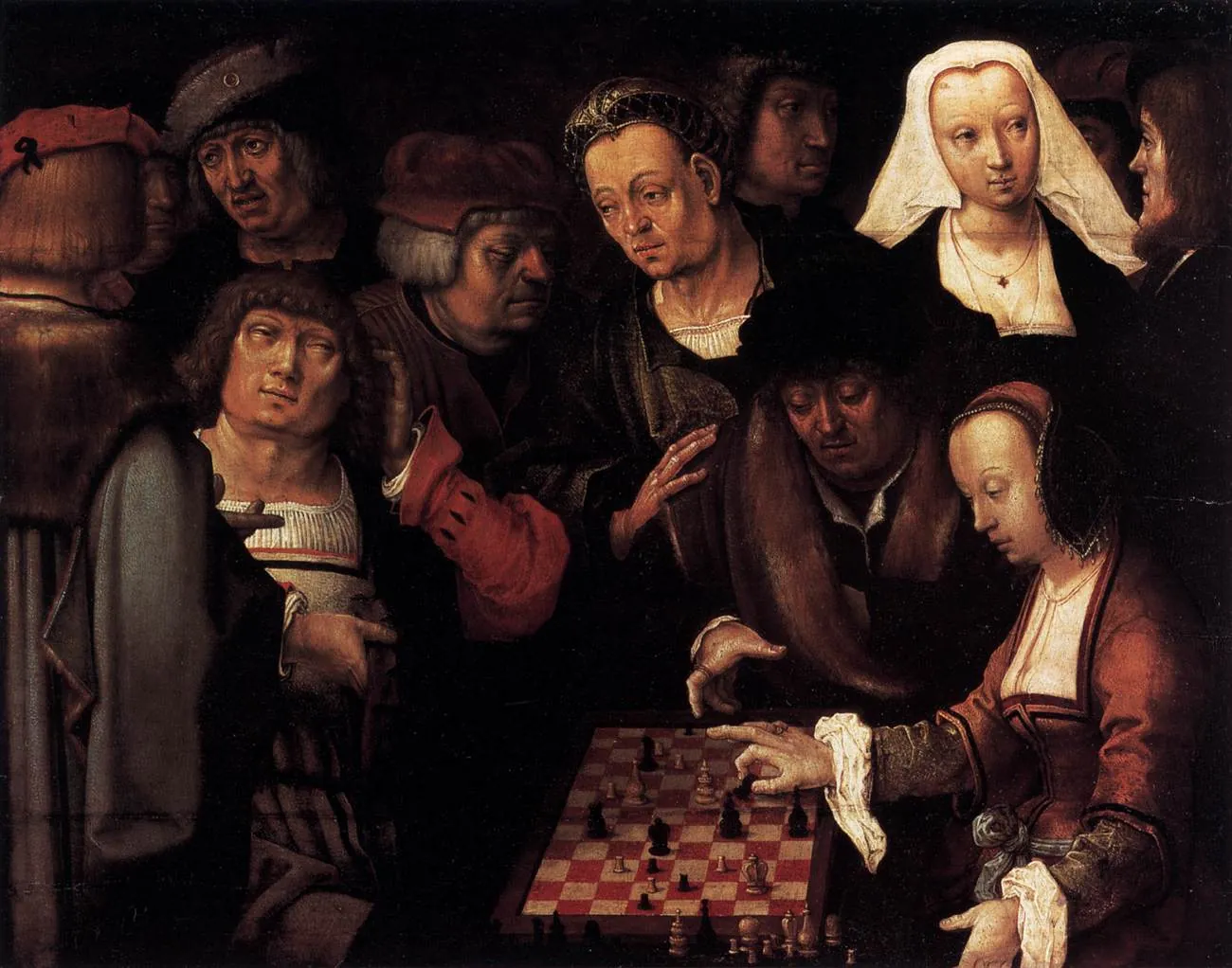 A woman and a man play chess on a large board while a crowd of onlookers leans in
